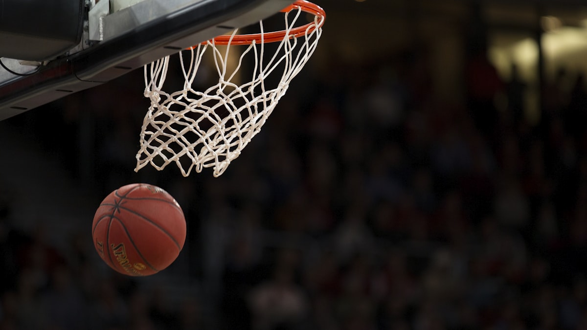 NBA季后赛东西部决赛激烈对抗场景，球员在篮下争夺篮板球